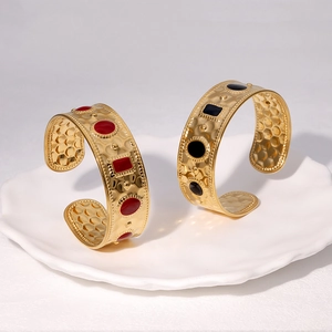 Detail of 18K gold plated open bangle with red and black enamel in honeycomb texture