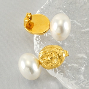 Close-up of pearl stud earrings with textured gold lava metal finish and soft luster