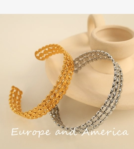 Close-up of gold and silver triple-row beaded open cuff bracelets in stainless steel