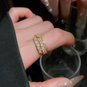 Macro detail of a triple-layered gold zircon ring featuring baguette-cut sparkling crystals