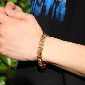 Close-up of a golden stainless steel Cuban link bracelet with a polished finish and clasp