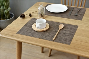 Close-up of brown woven PVC placemats with high heat resistance on a wooden dining table