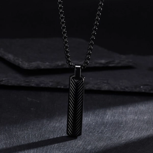 Macro shot of black stainless steel bar pendant featuring detailed herringbone engraving
