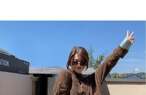Detail of autumn knit cardigan with brown texture and teal contrast cuffs outdoors