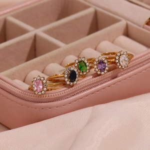 Detail of adjustable 18K gold plated rings with oval zirconias in a pink jewelry box