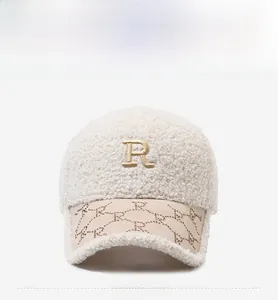 Detail of beige faux shearling baseball cap with golden embroidered R and suede brim