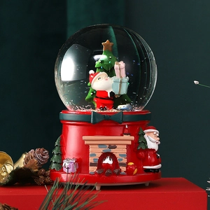 Close-up of a Christmas crystal ball music box with Santa Claus and a festive fireplace
