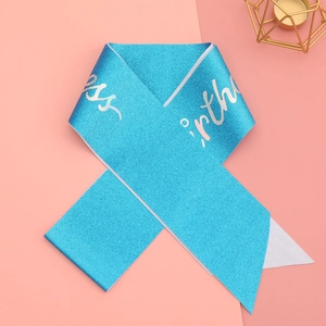 Blue glitter Birthday Princess sash with silver script on a pink and peach background