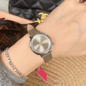 Detail shot of elegant women watch with diamond bezel and khaki leather strap on wrist