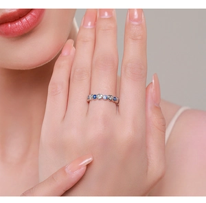 Detailed view of silver ring with heart crystal and blue eye gemstone on hand