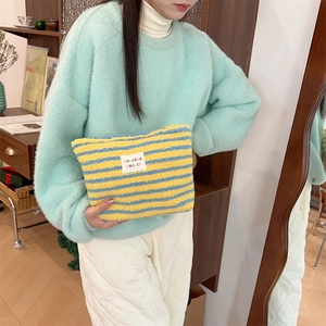 Large plush makeup bag with yellow and blue stripes for travel skincare storage