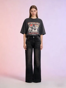 Dettaglio della t-shirt grigio antracite stampata e dei jeans neri lavati a vita alta larghi