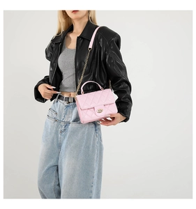 Détail du sac bandoulière rose matelassé avec chaîne dorée et fermoir rotatif en métal