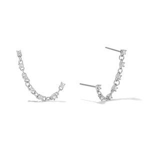 Macro detail of long silver chain earrings with shimmering cubic zirconia settings