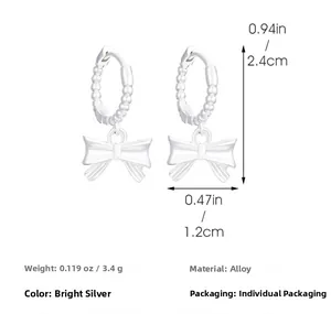 Boucles d'oreilles nœud argenté, dimensions 2,4cm par 1,2cm sur fond blanc pur