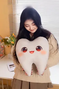 Gros plan d'un coussin en peluche en forme de dent avec visage de dessin animé mignon