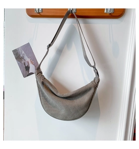 Detail of grey corduroy crescent bag showing vertical rib texture and top zipper