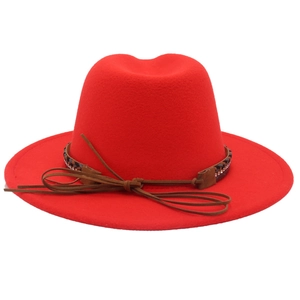 Dettaglio di cappello fedora rosso con fascia di paillettes e fiocco in cuoio decorativo