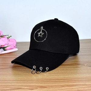 Detail of black cotton baseball cap featuring silver star ring and brim piercing accents