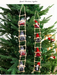 Detail of wool felt Santa Claus and gnome hanging ladder ornaments on a Christmas tree