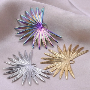 Three palm leaf pendants in rainbow, silver, and gold finishes for DIY jewelry design