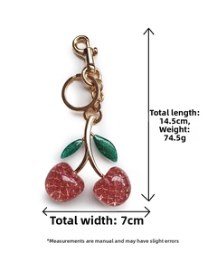 Detail view of cherry keychain with size specs 14.5cm length and red sequin finish