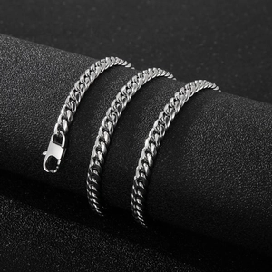 Detailed close-up of a silver Cuban link necklace with lobster clasp on a black stand