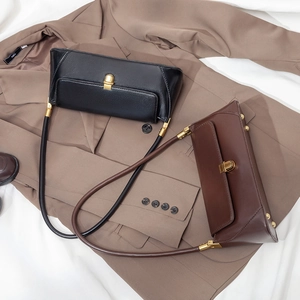 Flat lay of retro leather baguette bags in black and brown colors on a blazer