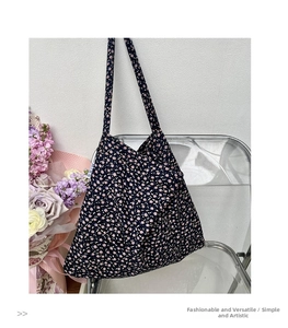 Floral canvas tote bag with navy blue base and pink flowers on an acrylic chair