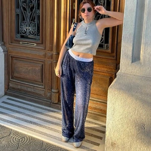 Detail of a gray knit halter top paired with blue sequined wide-leg shorts in a street style