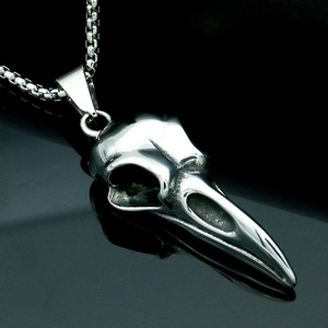 Macro shot of silver bird skull pendant in titanium steel with a detailed metallic finish