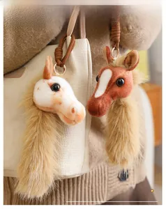 Plush horse head bag charm with faux fur tassel on a beige woven crossbody bag