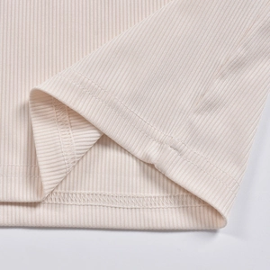 Dettaglio dell'orlo a coste e cuciture a doppio ago su tessuto a maglia beige