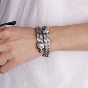 Close-up of double-strand twisted steel wire bracelets with vintage skull charms
