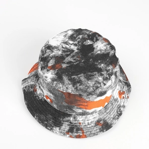 Detail of double-sided tie-dye bucket hat with black white and orange splash pattern