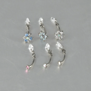 Close-up of G23 titanium belly rings with opal teardrops and zircon flower accents