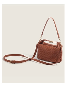 Detailed side view of brown woven crossbody bag with adjustable strap and metal hardware