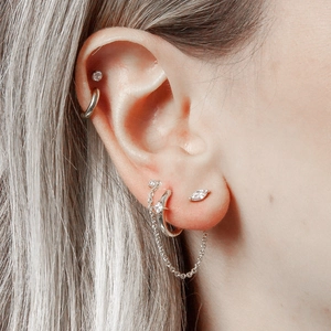 Detail of s925 silver eye-shaped stud and chain fringe earring set on a model