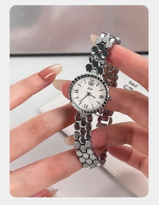 Close-up detail of the silver honeycomb bracelet watch band and bee logo dial