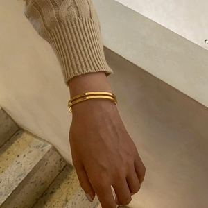 Minimalist double-layered 18k gold-plated stainless steel open bangle on a wrist