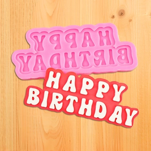 Dettaglio dello stampo HAPPY BIRTHDAY in silicone con lettere di fondente su legno