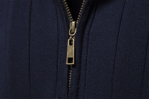 Macro shot of high-quality navy blue knit texture and vintage bronze metal zipper detail