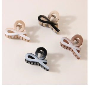 Detail of four gradient color hair claw clips in elegant ribbon twist design