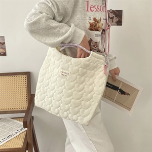 Détail du sac cabas en toile matelassée blanche avec poignées violettes et bandoulière