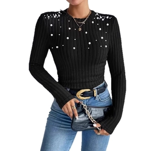 Detailed view of women's black ribbed knit top with elegant pearl embellishments