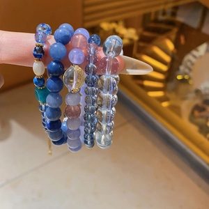 Macro detail of blue zircon crystal beaded stretch bracelets with tiered layering style