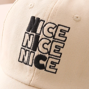 Close-up of high-density NICE letter embroidery on a beige cotton baseball cap detail
