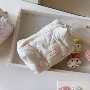 Vue détaillée du sac à maquillage matelassé avec fleurs roses et fermeture éclair