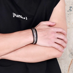 Men's multi-layer woven black leather bracelet with stainless steel accents on a model
