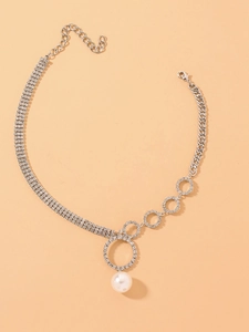 Detail of silver geometric circle necklace with pave rhinestones and large white pearl
